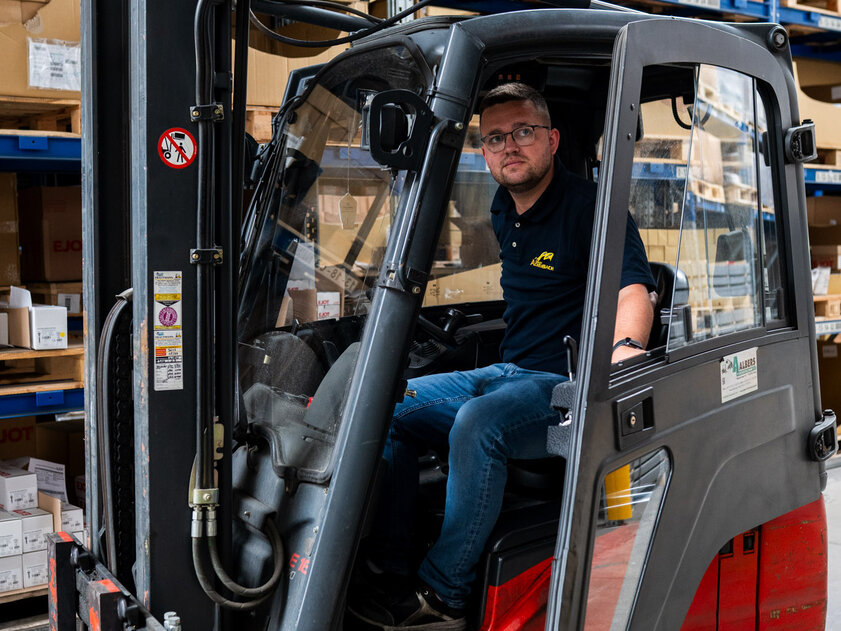 Marcel Bicher, Mitarbeiter im Wareneingang und Versand bei Achenbach Logistik, im Gabelstapler im Lager