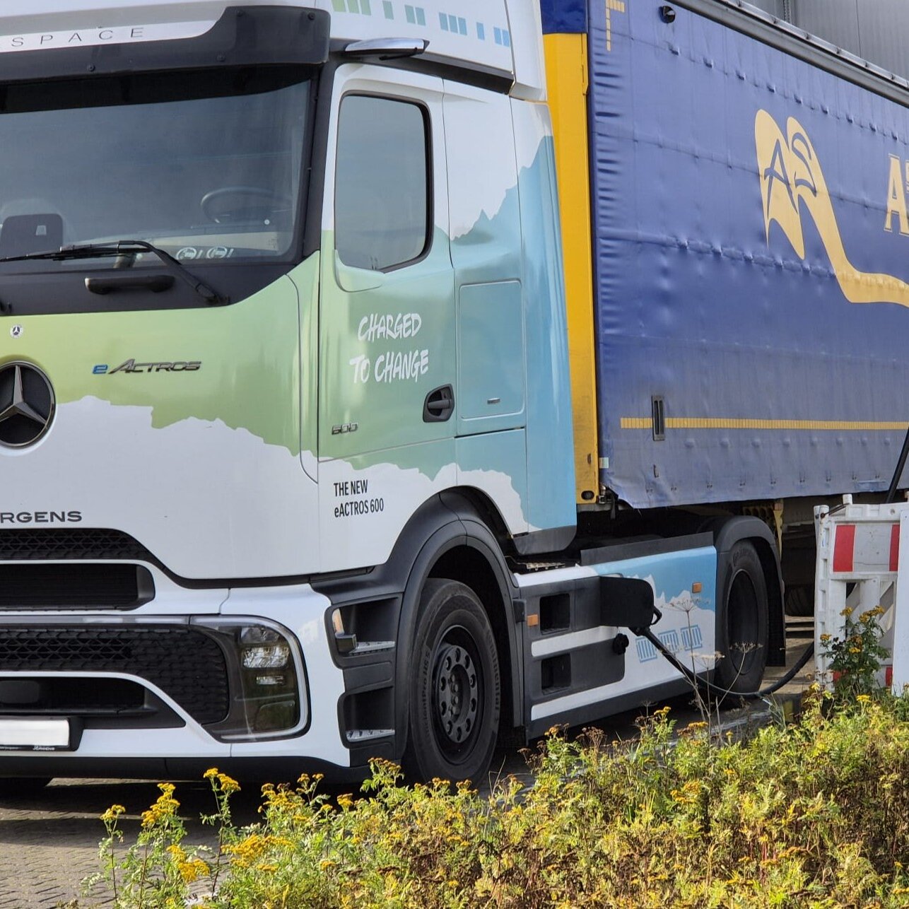 Moderner E-Lkw steht an elektrischer Ladesäule