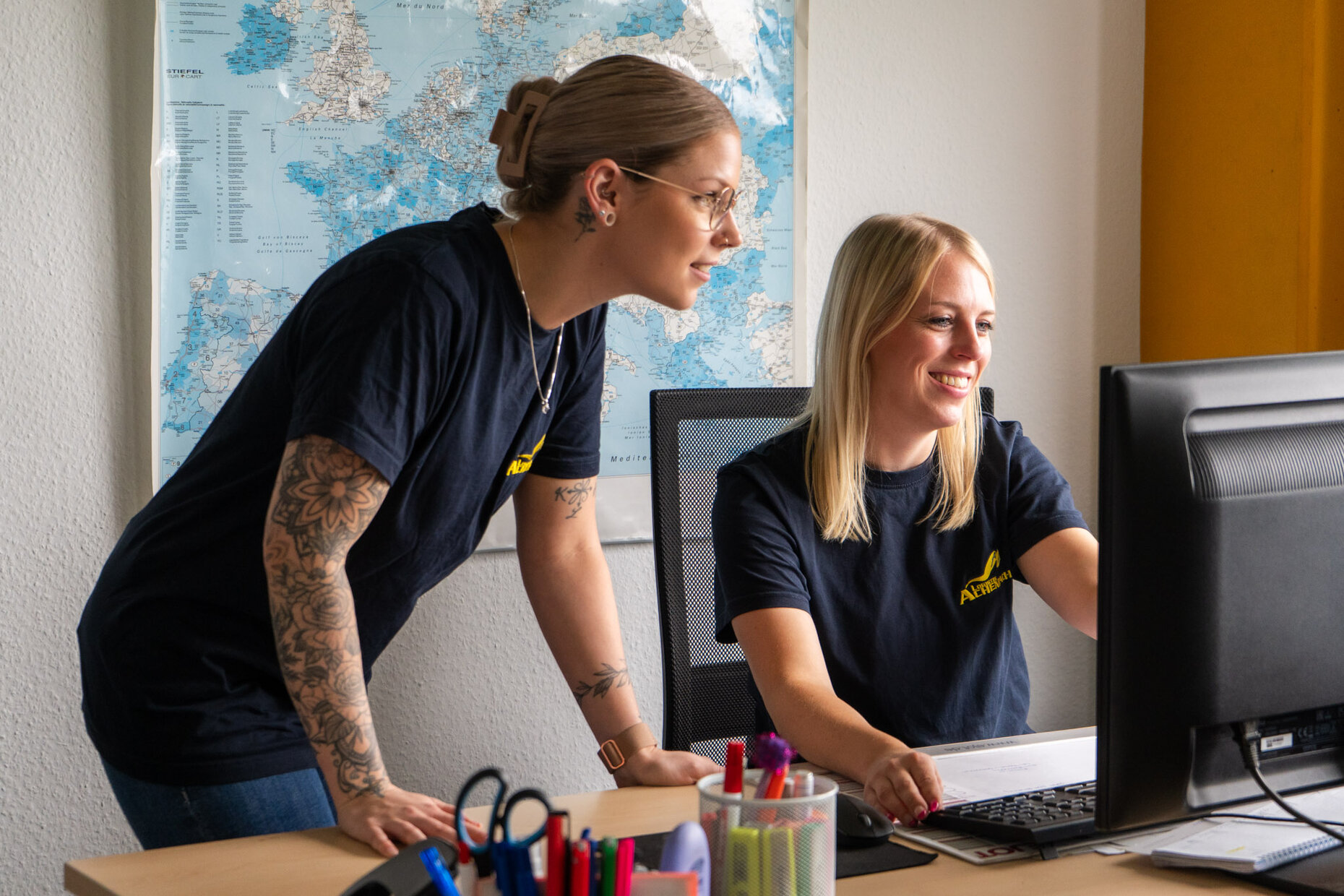 Zwei Auszubildende im Bürobereich der Achenbach Spedition im Gespräch