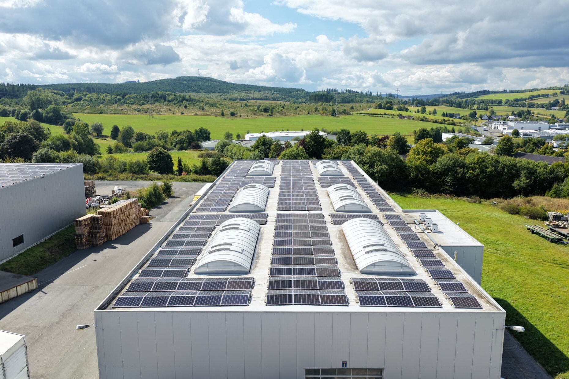 Dach der Achenbach-Logistikhalle mit großflächiger Photovoltaikanlage im Grünen