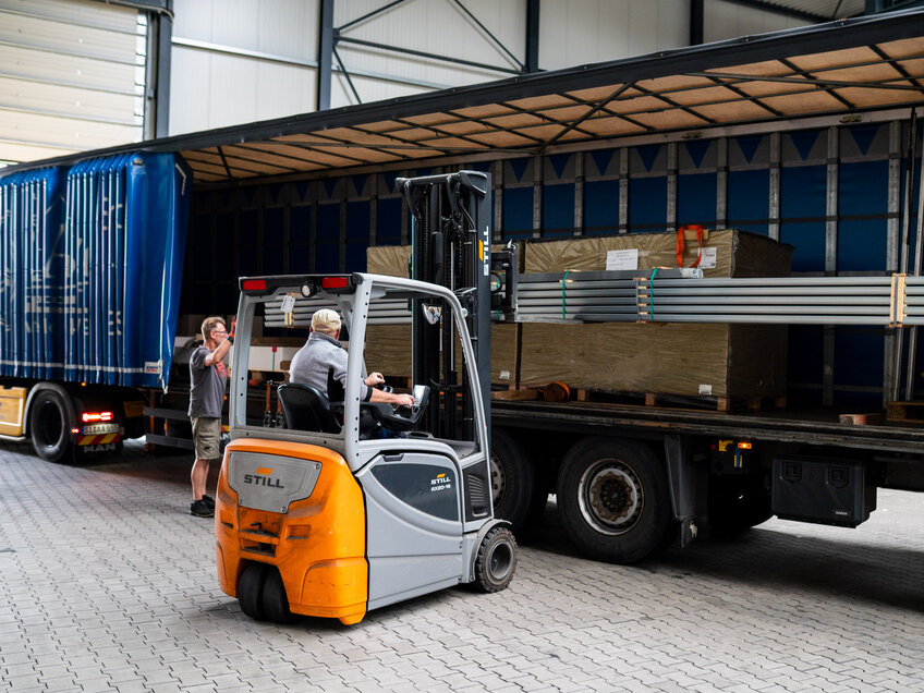Gabelstapler entlädt Lkw im Lagerbereich der Achenbach Logistik