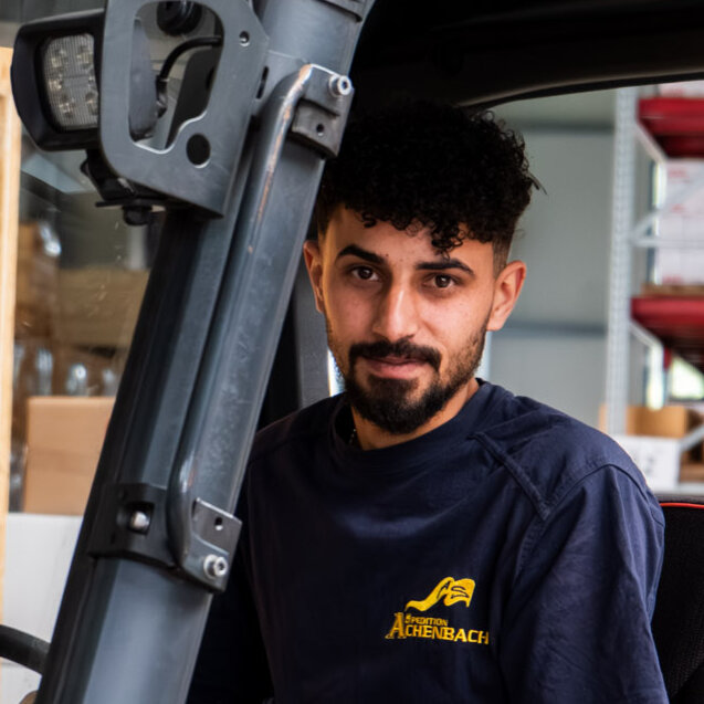 Mitarbeiter Adel sitzt auf dem Gabelstapler in der Lagerhalle
